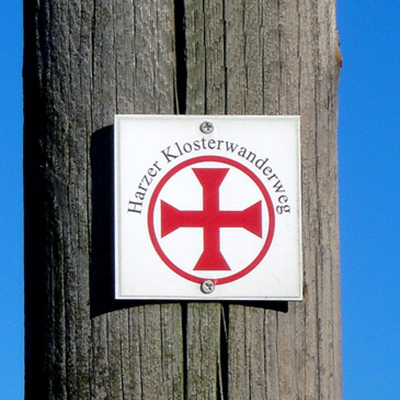 Logo des Harzer Koster-Wanderwegs an einem Pfahl