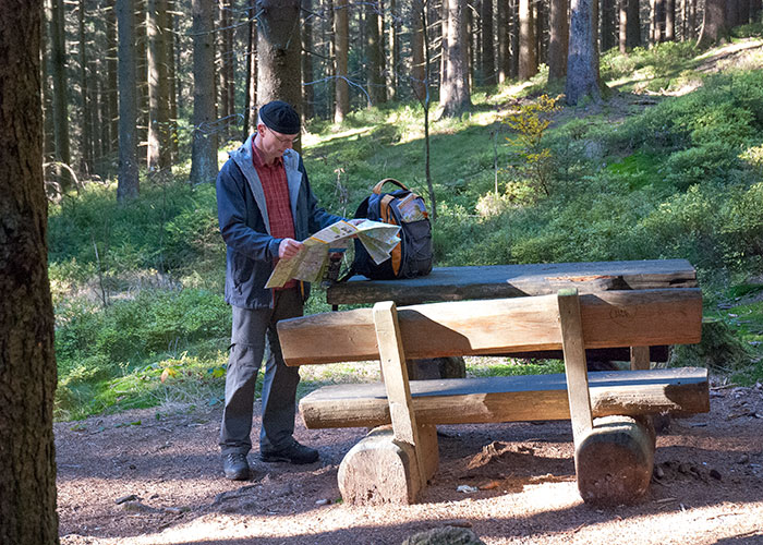 Ein Wanderer schaut in eine Harz-Wanderkarte